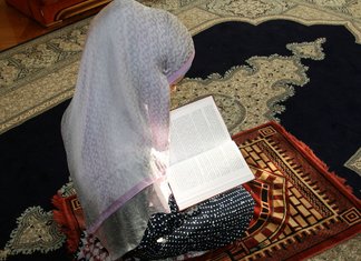 Musulmonė moteris meldžiasi dėl namų valymo