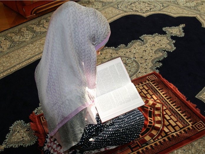 Muslimsk kvinne som ber om husrengjøring
