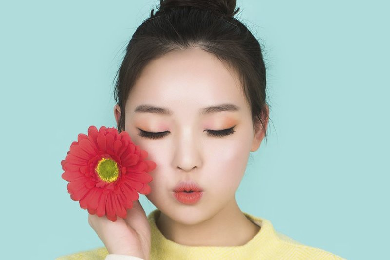 Koreansk kvinne med en blomst