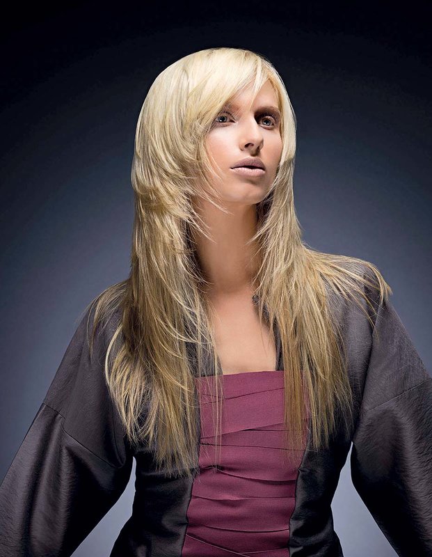 Jente med en hårklippskaskade på langt hår kombinert med smell