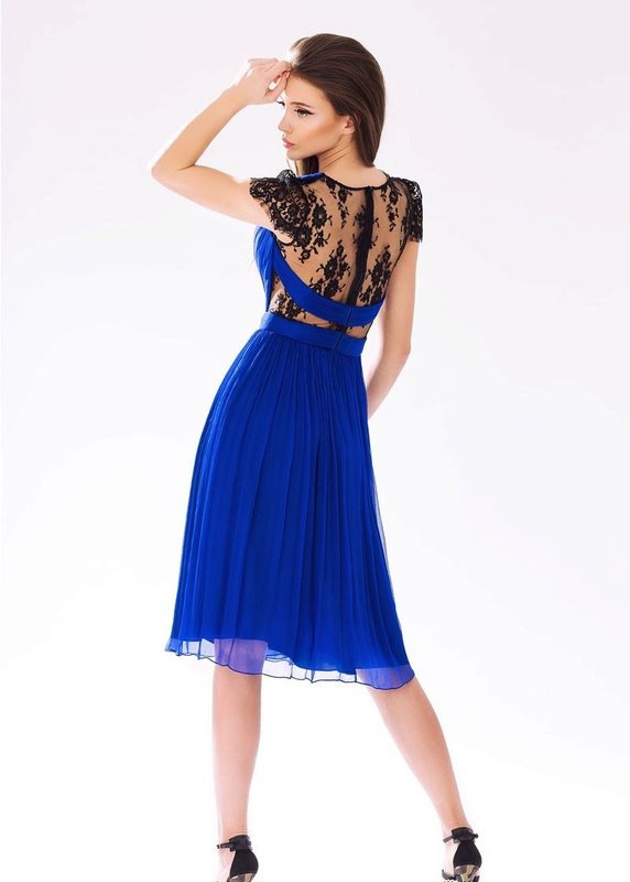 Mergaitė mėlynos spalvos kokteilių suknelėje su nėriniais ant nugaros
