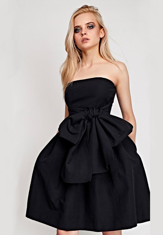 Fille dans une robe de cocktail noire avec une jupe évasée