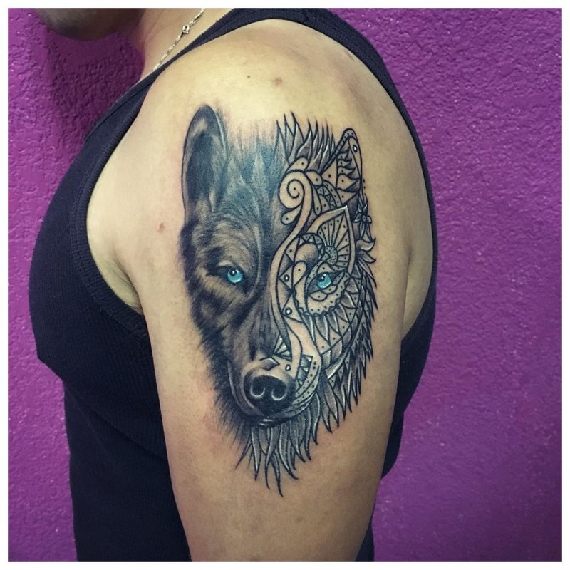 Mix de stiluri - un tatuaj de lup pe brațul unui bărbat