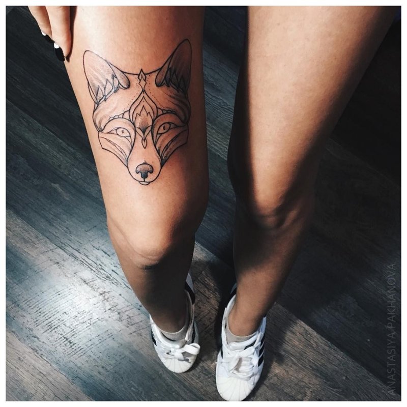 Ulve ansikt - tatovering på jentens bein