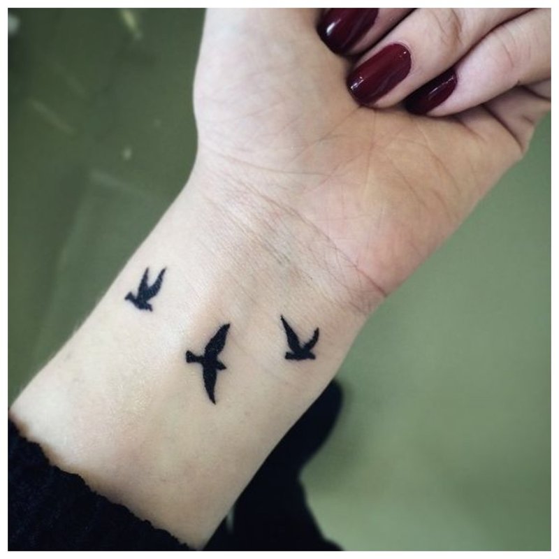 Tatouage en forme d'oiseaux sur la main de la fille