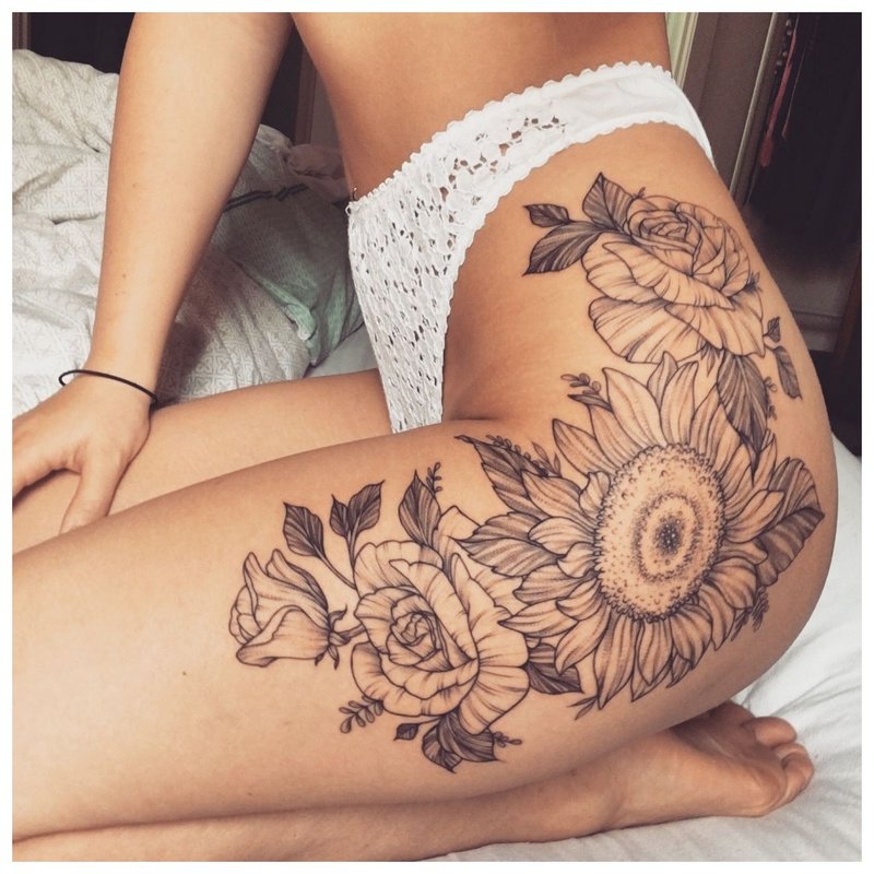 Didelė gėlė - tatuiruotė ant klubo mergaitės