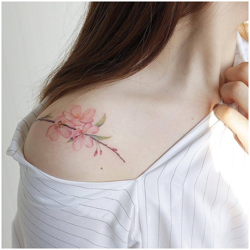 Délicat tatouage floral sur l'épaule