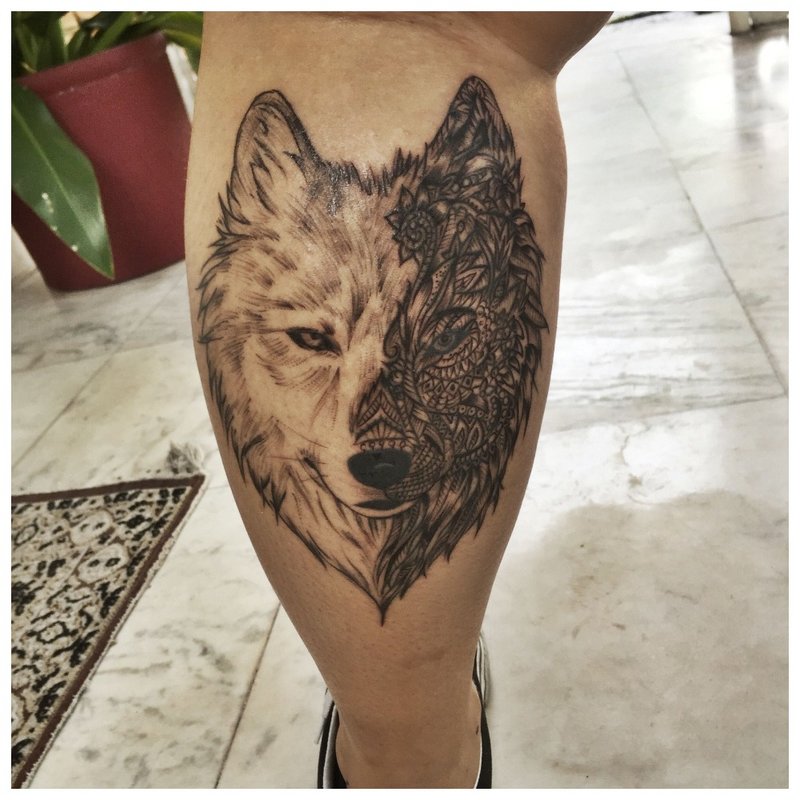 Frumos tatuaj de lup pe vițelul unui bărbat