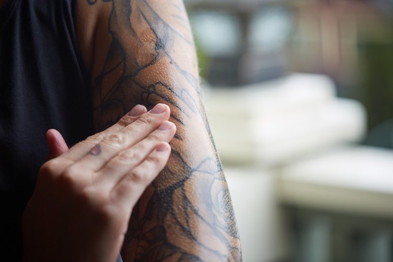 Fille frottis un tatouage avec pommade