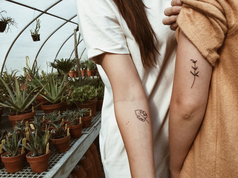 Pora su tatuiruotėmis ant rankos.