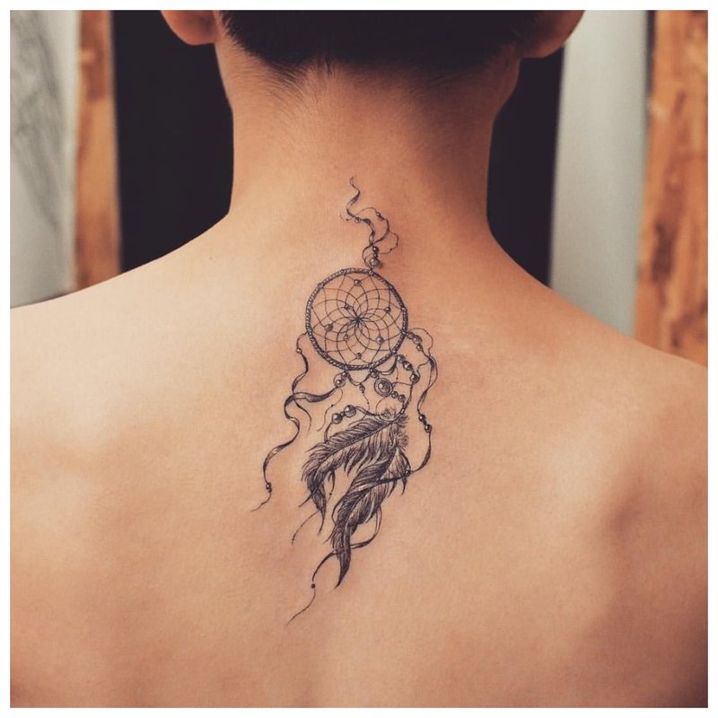 Tatuiruotės amuletas ant merginos nugaros
