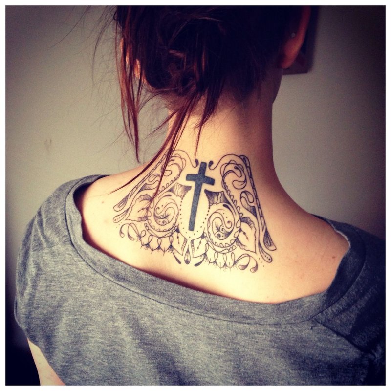 Tatuiruotės kryžius ant merginos kaklo nugaroje